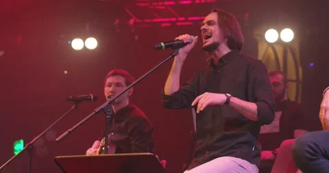 Men singing to microphone on light background. Stylish cool guy performing Video stock 154323553