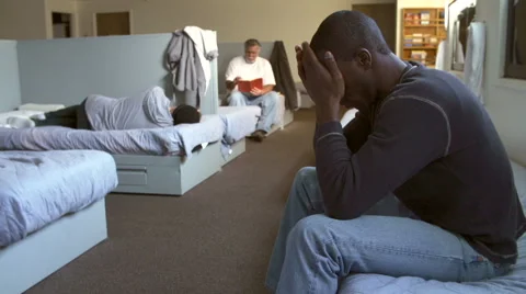 Men Sitting On Beds In Homeless Shelter Stock Footage