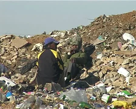 Men sitting at the dump site Stock Footage 11496740