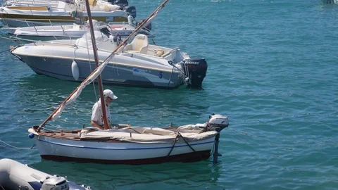 Men sitting inside a small boat in the harbor Stock Footage 91185430