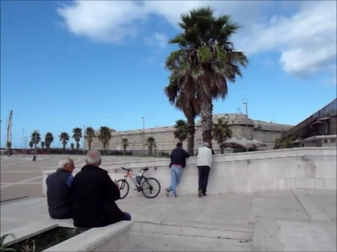 Men sitting on the wall and standing against a wall Stock Footage 118127867