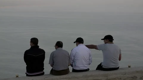 Men sitting on wall overlooking  the Sea Stock Footage 68693367