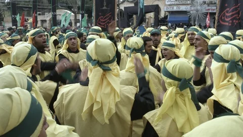 Men slap their chests during Hezbollah's Ashoura procession in Nabatieh, Lebanon Stock Footage 119946200