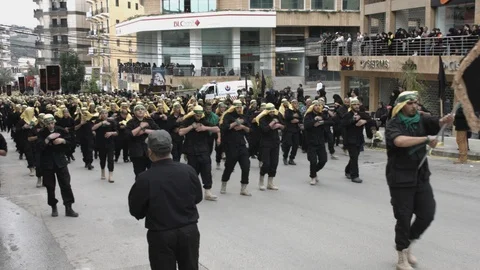 Men slap their chests during Hezbollah's Ashoura procession in Nabatieh, Lebanon Stock Footage 119948429