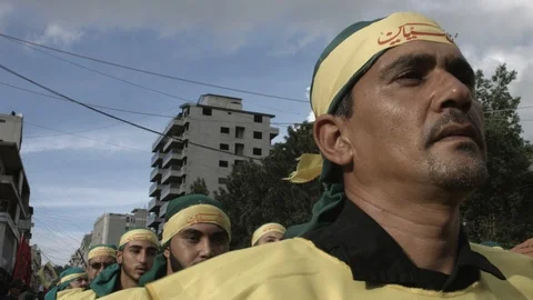 Men slap their chests during Hezbollah's Ashoura procession in Nabatieh, Lebanon Stock Footage 119948778