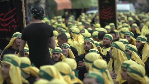 Men slap their chests during Hezbollah's Ashoura procession in Nabatieh, Lebanon Stock Footage 120589961