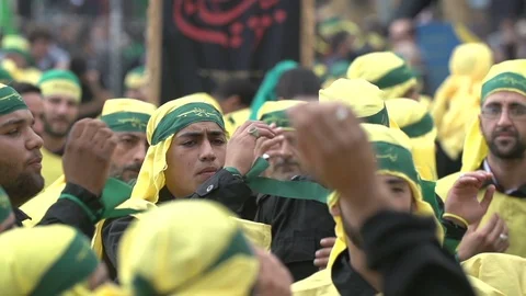 Men slap their chests during Hezbollah's Ashoura procession in Nabatieh, Lebanon Stock Footage 120590020