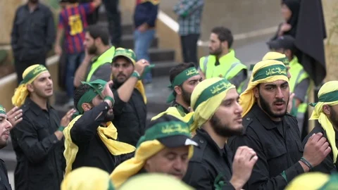 Men slap their chests during Hezbollah's Ashoura procession in Nabatieh, Lebanon Stock Footage 120592811