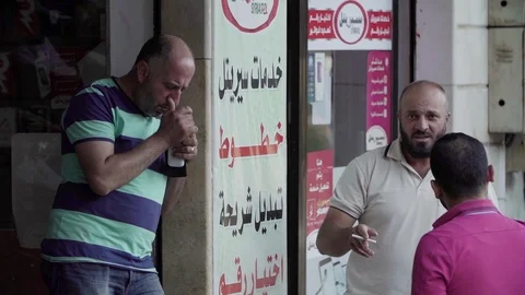 Men smoke cigarettes on the side of a road in Bloudan, Syria Stock Footage 121807548