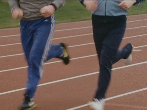 Men sprinting on running track while man is talking about health, England, 1985 Stock Footage 134026052