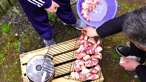 Men stack meat on barbecue Stock Footage 151464824