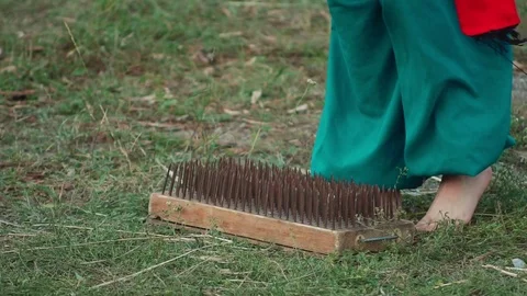Men stand on the board with nails. Slow motion Stock Footage 69974091