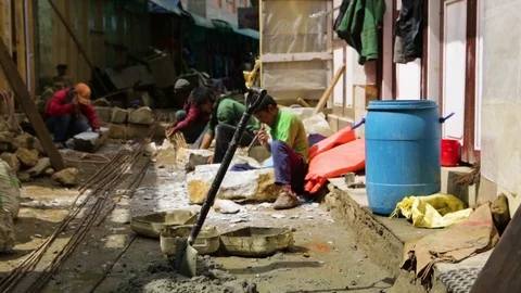 Men staying busy by shaping rocks with hammers in a narrow passage Stock Footage 77448162