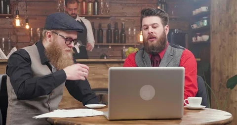 Men in stylish suits and with nice beards are having a video conference in an Stock Footage 104976652