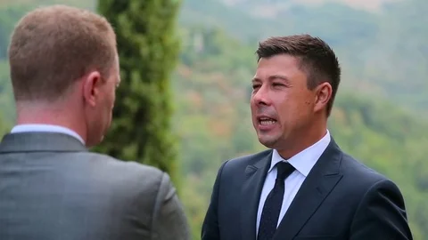 Men in suits talking in the garden Stock Footage 69903945