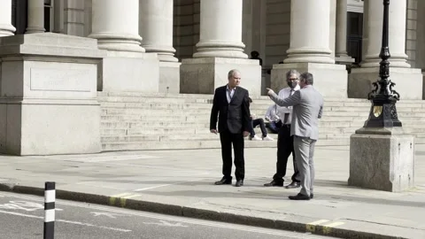 MEN IN SUITS WATCH AS WORKERS CLEAN BANK OF ENGLAND AFTER EXTINCTION REBELLION Stock Footage 151474338