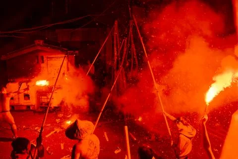 Men swing burning firecracker strings at Shezidao Earth God Lantern Festival Fotos Stock