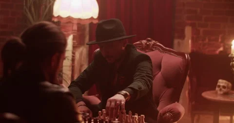 Men at table playing chess in dark room Stock Footage 260558154