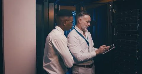 Men, tablet and team in server room with maintenance, review and talk with Stock Photos