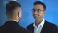 The men talk and pat shoulder on the blue background. slow motion 4k or 4k+ Resolution