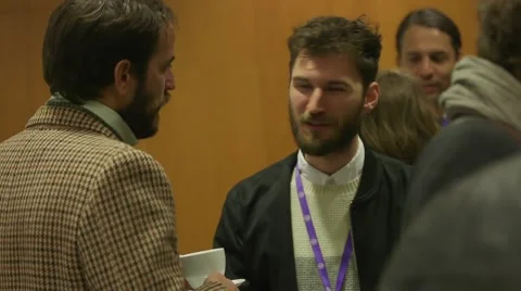 Men talking and drinking coffee at a corporate networking event Stock Footage 64565848