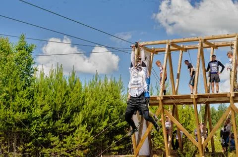 Men is transported on rope through the river Stock Photos