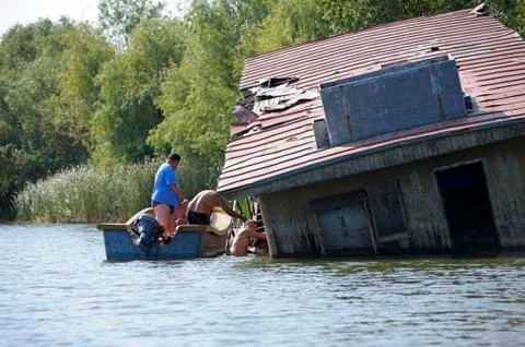 Men trying to get inside of the abandoned ship to find something useful to st Stock Photos