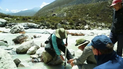 Men trying to measure the distance between two rocks Stock Footage 77450143