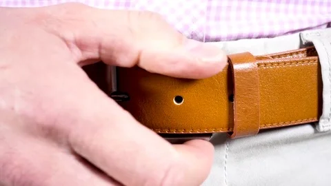 Men uclasps fly and button on his chino - unbuckling belt Stock Footage 84063319