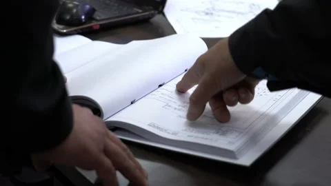 Men in uniform leafing through a folder with documents Stock Footage 220712511