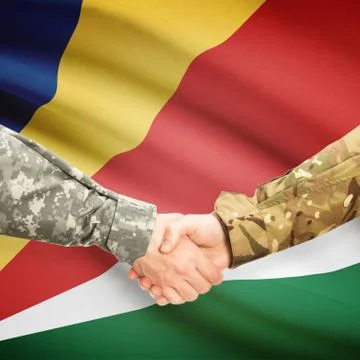 Men in uniform shaking hands with flag on background - Seychelles 写真素材