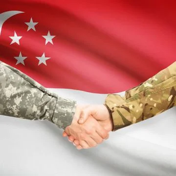Men in uniform shaking hands with flag on background - Singapore Stock Photos
