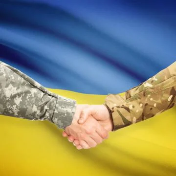 Men in uniform shaking hands with flag on background - Ukraine 스톡 사진
