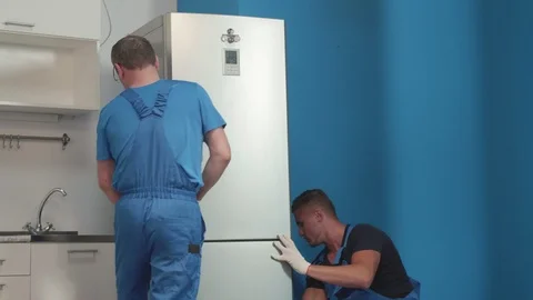 Men in uniform take a fridge. Stock Footage 116542452