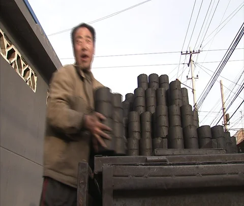 Men unloading coal ash bricks from truck and stacking them on ground Stock Footage 86745449