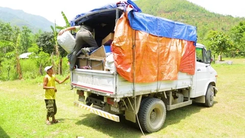 Men unloading items from a truck Stock Footage 77444317