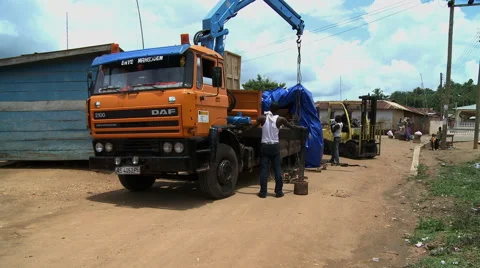 MEN UNLOADING ORANGE TRUCK IN PAKRO Stock Footage 58106598