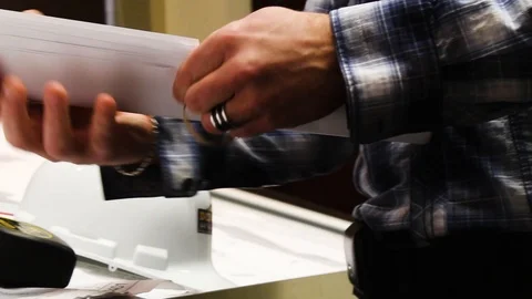 Men unrolling construction plan on office desk, architect, blueprint Stock Footage 87346577