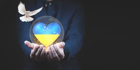 Men use both hands to support the heart of the Ukrainian flag and the white d Stock Photos