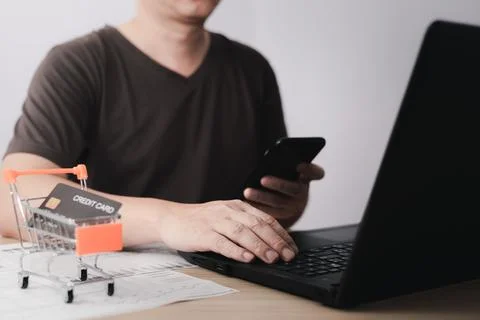 Men use laptop computers and smartphone for business commerce, which is pay.. Stock Photos