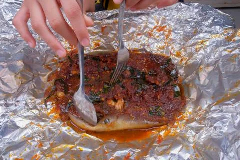 Men use spoons and fork  while eating grilled stingray with hot spicy in alum Stock Photos