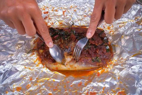 Men use spoons and fork  while eating grilled stingray with hot spicy in alum Stock Photos