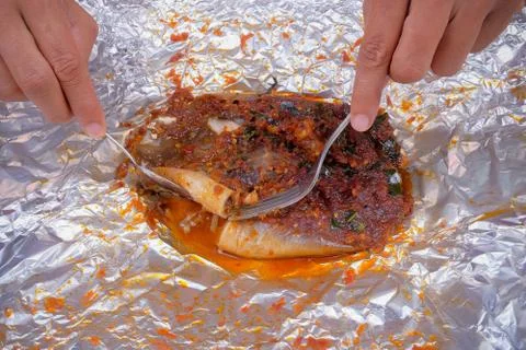 Men use spoons and fork  while eating grilled stingray with hot spicy in alum Stock Photos