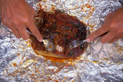 Men use spoons and fork  while eating grilled stingray with hot spicy in alum Stock Photos