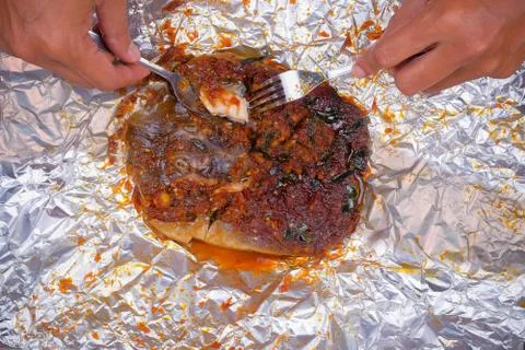 Men use spoons and fork  while eating grilled stingray with hot spicy in alum Stock Photos