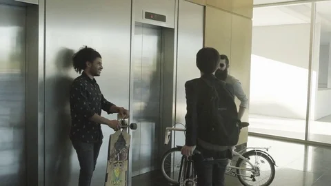 Men waiting by elevator with bikes and skateboard Stock Footage 75183379