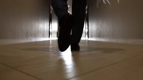 Men walking along a narrow corridor with a green carpet, close-up Vidéo 129260643