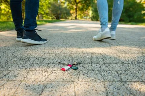 Men walking outside, focus on lost keys Stock Photos