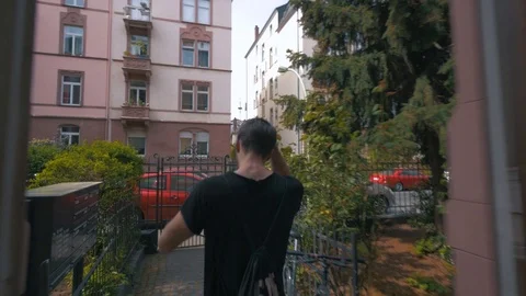 Men walking outside a house putting on a cap Stock Footage 87261676