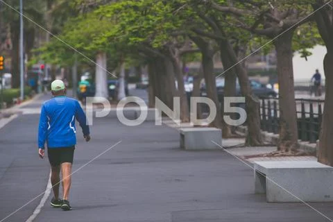 Men walking in sports wear on promenade. Photography in vintage style. Stock Photos